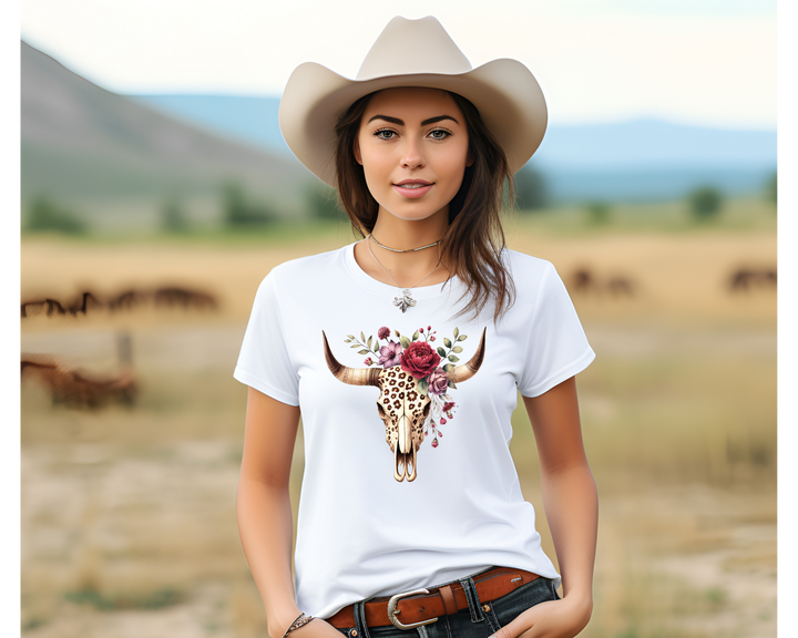 Woman wearing a white t-shirt with a bull skull design in a field