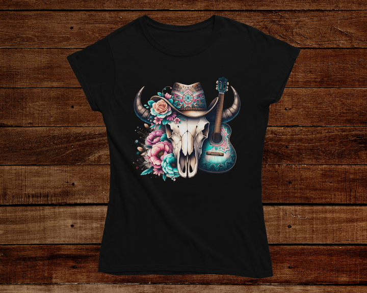 Black t-shirt with a bull skull, guitar, and hat design on a wooden background