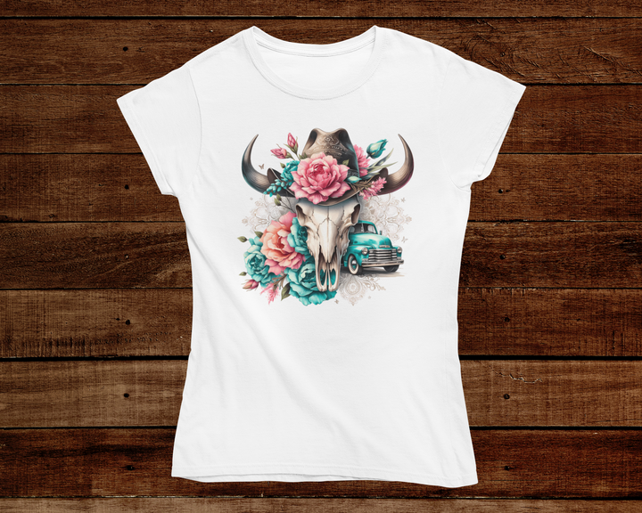 White t-shirt with a graphic design of a bull skull with flowers and a truck on a wooden background