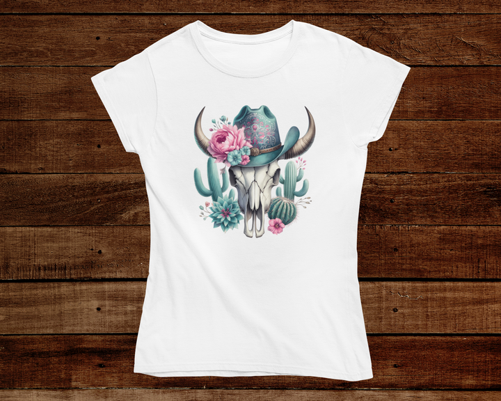 White t-shirt with a graphic design of a cow skull, flowers, and cacti on a wooden background