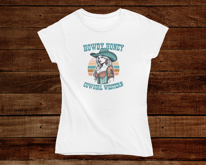 White t-shirt with a cowgirl graphic and 'Howdy Honey Cowgirl Western' text on a wooden background