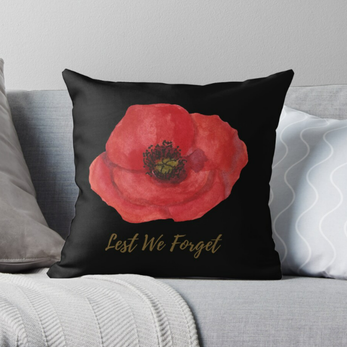 Black cushion with red poppy and Lest We Forget text